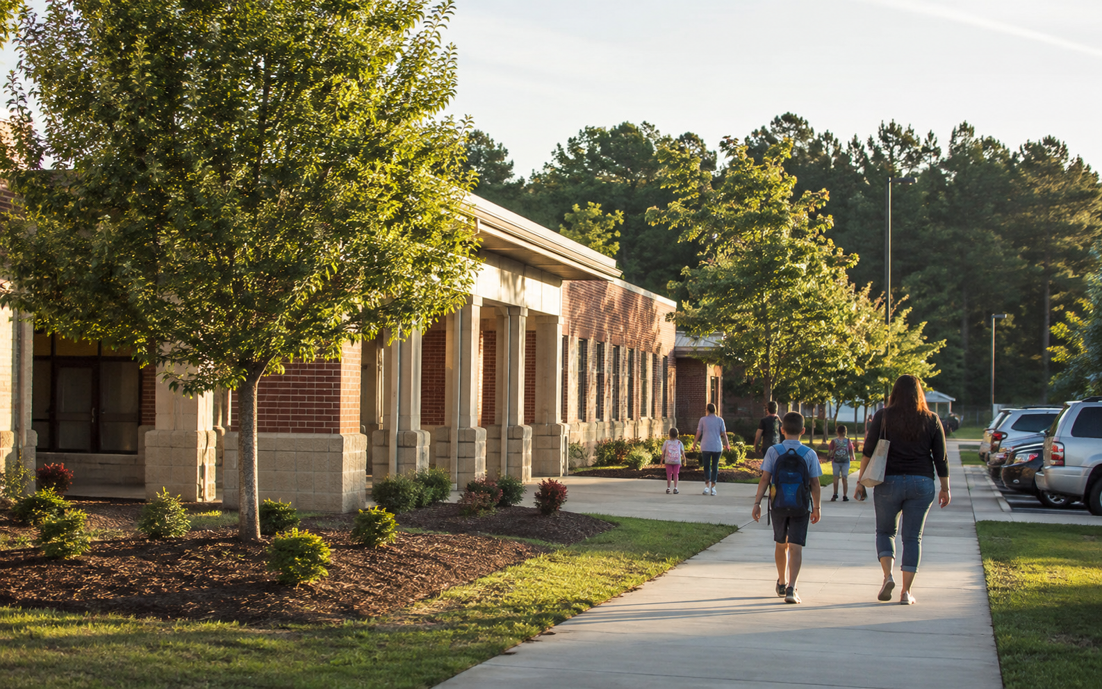 Families and students walking toward a suburban school campus in Columbia County.